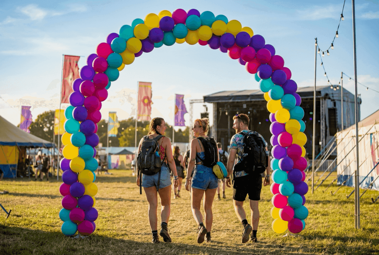Portal de globos PilaMania como entrada de festival con público atravesando