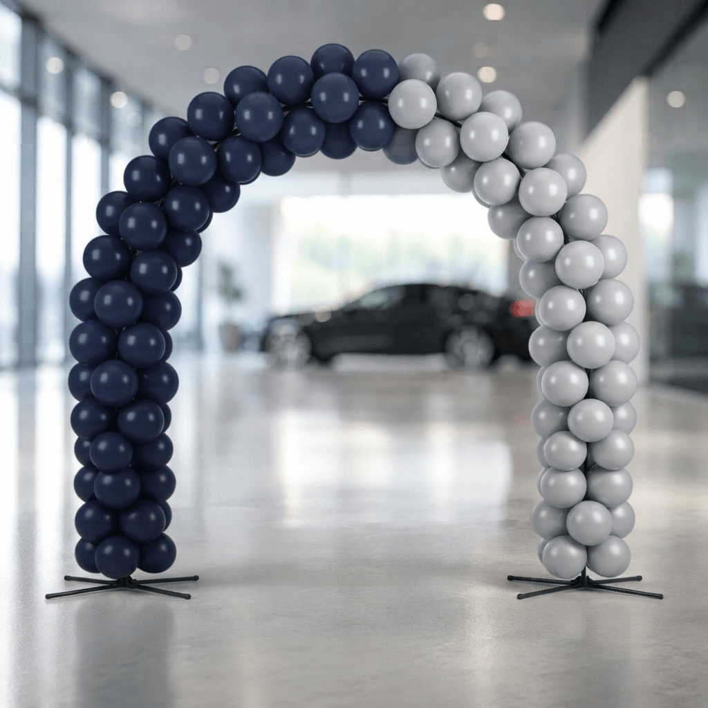 Arco de globos en azul marino y gris plata sobre el paso de un showroom de concesionario