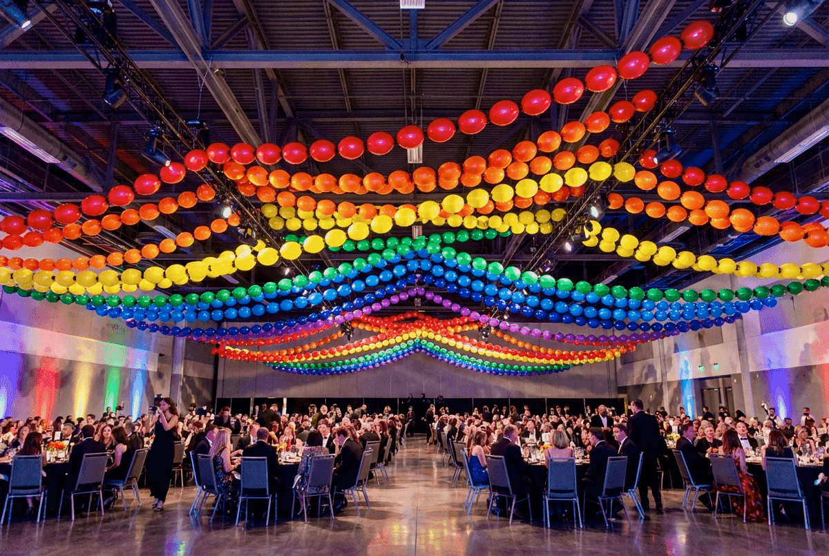 Larga guirnalda de globos arcoíris sobre recinto de festival