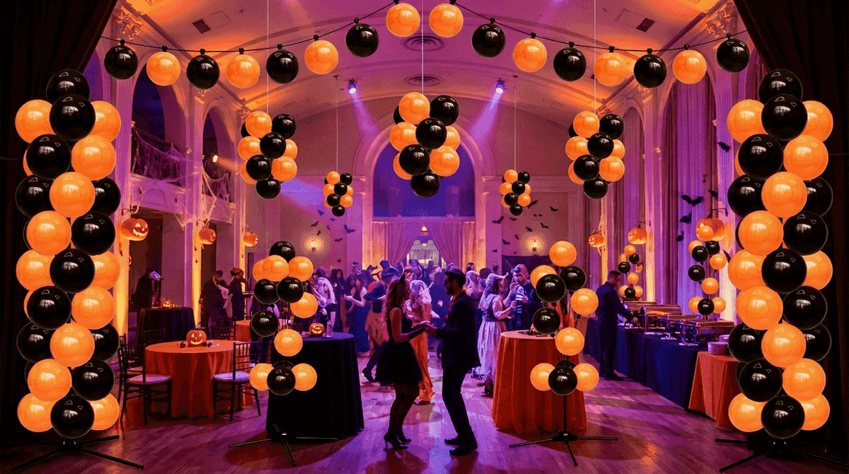 Evento de gala de Halloween con arcos de globos naranjas y negros e invitados bailando