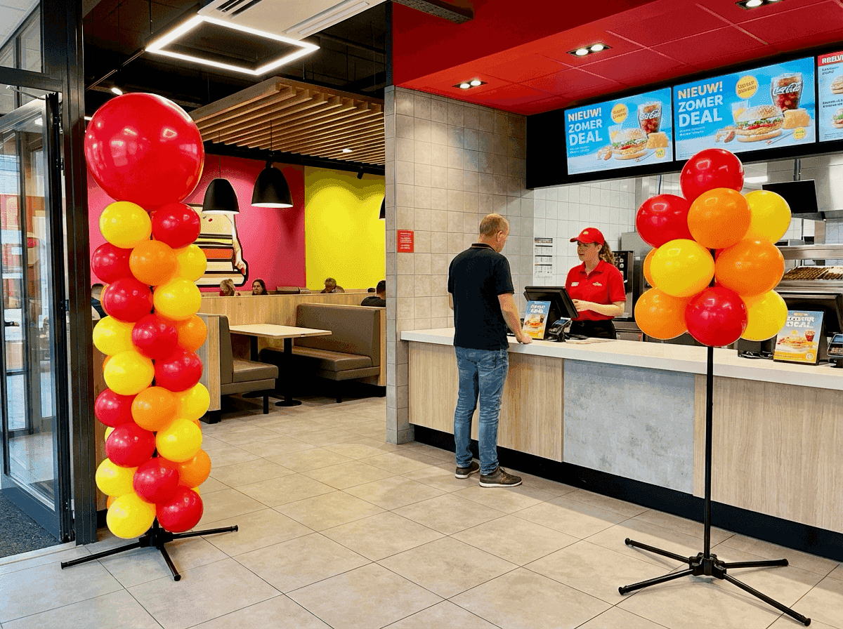 Restaurante de comida rápida con decoración de globos rojos y amarillos para una promoción