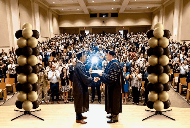 Elegantes columnas de globos en colores neutros en ceremonia de graduación universitaria