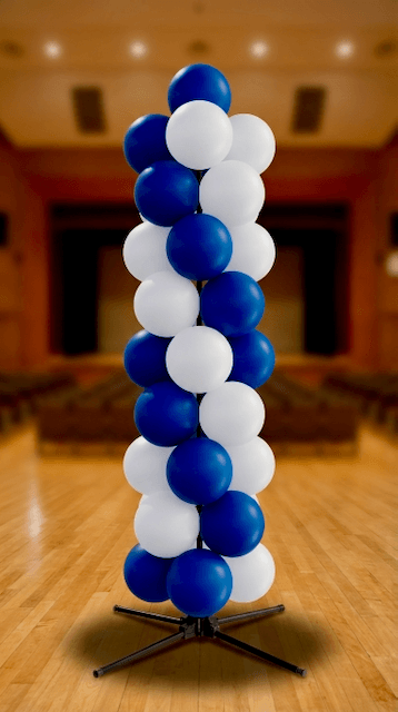 Vista general de montaje completo de graduación con columnas de globos y arco PilaMania en colores institucionales